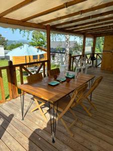 a wooden table and chairs on a wooden deck at mobil-home cosy, calme, therme, aquensis, casino in Bagnères-de-Bigorre