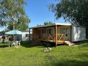 une petite cabine avec une table et un parasol dans l'établissement mobil-home cosy, calme, therme, aquensis, casino, à Bagnères-de-Bigorre