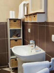 y baño con lavabo, cestas y toallas. en Apartmani Roko, en Okrug Donji