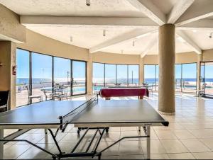 a ping pong table in a room with a view of the ocean at Calafia, Oceanview Condo Resort in Rosarito. in Rosarito