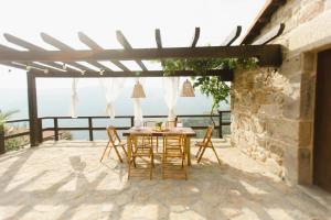 una mesa y sillas en un patio con vistas al océano en Apedeceo Belesar Villa, Ribeira Sacra, Galicia, en Chantada