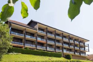 an apartment building with bushes in front of it at Duplex Le Reflet du Lac in Malbuisson