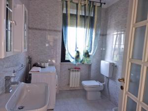 ein weißes Bad mit einem Waschbecken und einem WC in der Unterkunft Appartamento Divino Tramonto in Altedo