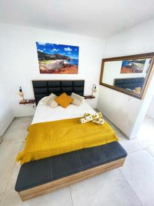 a bedroom with a large bed with a yellow blanket at Sunrise IN LOFT in Playa Honda