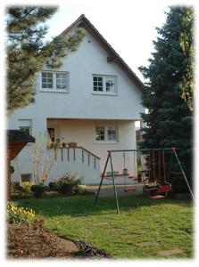 une maison avec une aire de jeux en face dans l'établissement Ferienwohnung Witzig Inh Rita Weitmann, à Ingelheim-sur-le-Rhin