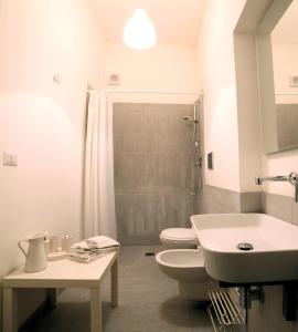 シラクーサにあるAppartamenti di charme Ortigia Marilini Duliniのバスルーム(トイレ2つ、シンク、シャワー付)