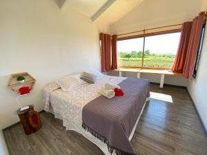 a bedroom with a bed with two stuffed animals on it at Maunga Roa Eco Lodge in Hanga Roa