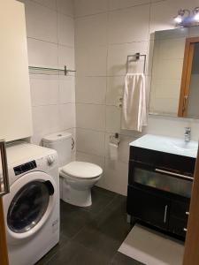 a bathroom with a washing machine and a toilet at Cozy apartment at a great location! in Hospitalet de Llobregat