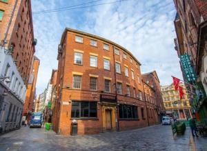 a brick building on a street in a city at Temple Court by UStay Aparthotels in Liverpool