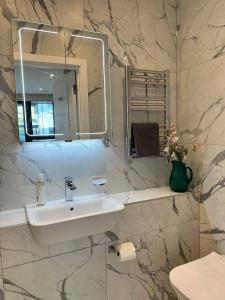 a bathroom with a sink and a mirror at Ramsgate Stunning Sea View Apt Free Parking in Kent +34 photos