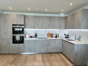a large kitchen with stainless steel appliances and wood floors at SoHot Stays Ramsgate Stunning Sea View Apt Free Parking in Kent