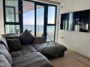 a living room with a couch and a large window at SoHot Stays Ramsgate Stunning Sea View Apt Free Parking in Kent