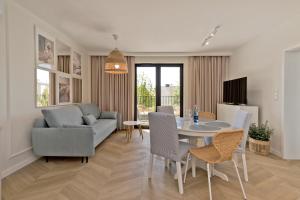 sala de estar con sofá, mesa y sillas en BlueApart Apartamenty Portowa, en Jastarnia
