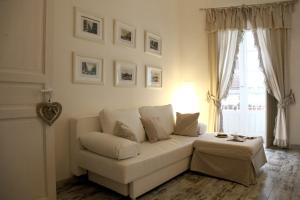 シラクーサにあるAppartamenti di charme Ortigia Marilini Duliniのリビングルーム(白いソファ、窓付)