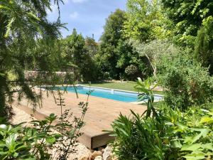 una piscina en medio de un jardín en Coeur de Roses, gîte & chambre d'hôtes en Alaigne