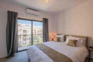 a bedroom with a large bed and a large window at Wanderlust 2 in Sliema