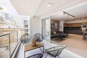 a living room with a balcony with chairs and a couch at The Ultimate Escape in Sliema