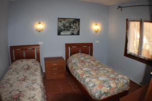 a bedroom with two beds and a dresser and lights at El Cisne - holiday home with private swimming pool in Benissa in Pedramala