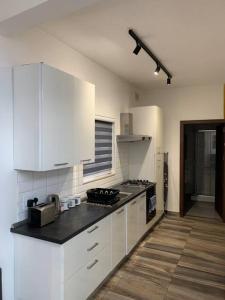 a kitchen with white cabinets and a black counter top at Fly Away Home condo with terrace in Qormi