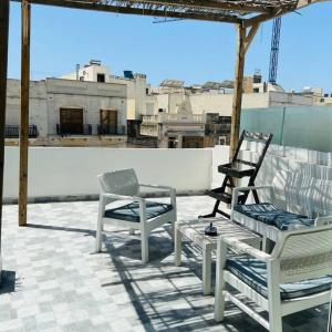 two chairs and a table on a roof at Fly Away Home condo with terrace in Qormi