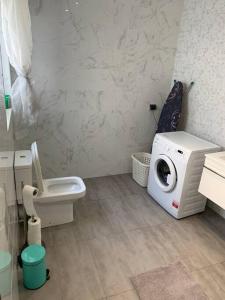 a bathroom with a washing machine and a toilet at Fly Away Home condo with terrace in Qormi