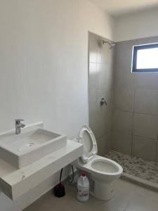 a white bathroom with a sink and a toilet at Departamento azinchite in Mazatlán