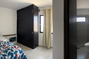 マサトランにあるDepartamento azinchiteのバスルームの隣に黒いキャビネット付きのベッドルームがあります。