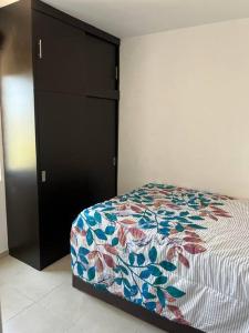 マサトランにあるDepartamento azinchiteのベッドルーム1室(ベッド1台、黒いキャビネット付)