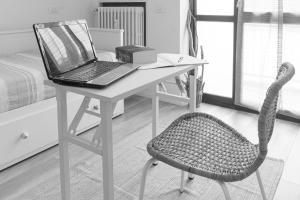 biurko z laptopem i krzesłem w pokoju w obiekcie Casetta Azzurra w mieście Pero
