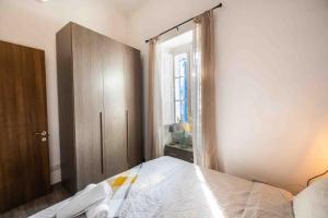 um quarto com uma cama, um armário e uma janela em Olivias em Qormi