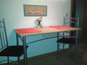 インゲルハイム・アム・ラインにあるFerienwohnung Witzig Inh Rita Weitmannのテーブル(椅子2脚付)とテーブル(赤いナプキン付)