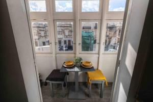 Olivias في Qormi: طاولة وكراسي في غرفة مع نافذة