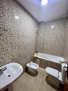 uma casa de banho com um lavatório, um WC e uma banheira em Appartement les résidences du rêve em Marrakech