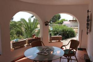 Habitación con mesa, sillas y balcón. en El Cisne - holiday home with private swimming pool in Benissa en Pedramala