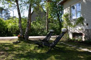 two chairs sitting in the yard of a house at Lovely nest in Nõmme in Tallinn