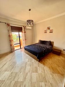 een slaapkamer met een bed en een houten vloer bij Appartement les résidences du rêve in Marrakesh