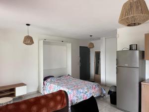 1 dormitorio con 1 cama y nevera. en Studio résidence les Villas de Melody, en Moriani Plage