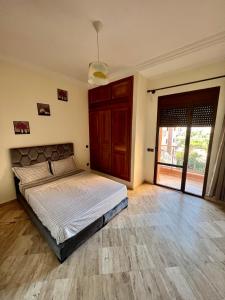 um quarto com uma cama e uma porta de vidro deslizante em Appartement les résidences du rêve em Marrakech