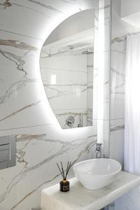 a bathroom with a white sink and a mirror at Villa Maina in Kamari