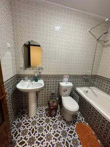 La salle de bains est pourvue d'un lavabo, de toilettes et d'une baignoire. dans l'établissement ESHONI PIR Boutique HOTEL, à Boukhara