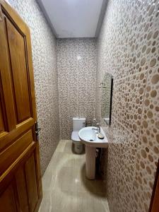baño con aseo, lavabo y puerta en Appartement les résidences du rêve en Marrakech