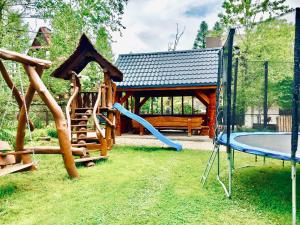 a playground with a slide and a swing set at Domek Iris in Kościelisko