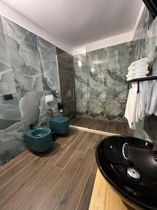 baño con lavabo negro y 2 aseos en Inn Hotel, en Vlorë