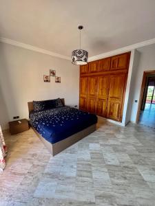 Schlafzimmer mit einem Bett mit blauer Decke in der Unterkunft Appartement les résidences du rêve in Marrakesch