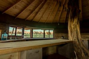 a kitchen with a wooden counter top and windows at Vernacular Lodge in San Pedro de Atacama