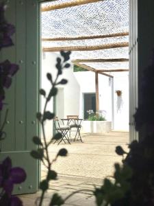 eine offene Tür zu einer Terrasse mit einem Tisch und Stühlen in der Unterkunft Alojamiento rural CASAPIÑA in Conil de la Frontera