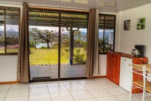 a kitchen with a large glass door with a view at Hotel Little Paradise in Nuevo Arenal