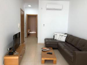 uma sala de estar com um sofá castanho e uma televisão em Tigne 3 Sliema one bedroom apartment em Sliema