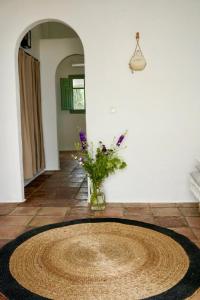 un jarrón de flores sentado en el suelo en una habitación en Alojamiento rural CASAPIÑA en Conil de la Frontera