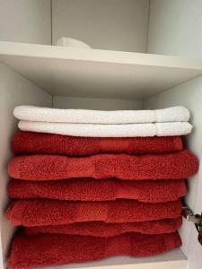 uma pilha de toalhas vermelhas num armário em Tigne 3 Sliema one bedroom apartment em Sliema